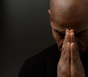 Close-up of senior man against black background