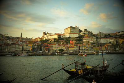 Sailboats in city at sunset