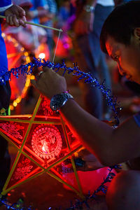 Man making illuminated decoration at workshop