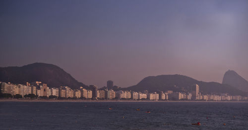 Scenic view of sea by buildings against sky