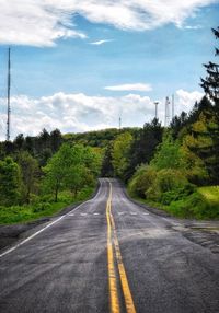 Road by trees against sky