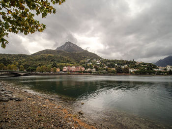 Scenic view of lake by buildings against sky