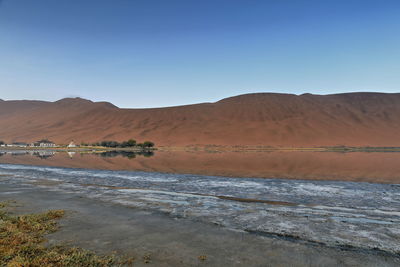 1124 sumu jaran lake and badain jaran desert temple-sand megadunes reflected on mirror water. china.