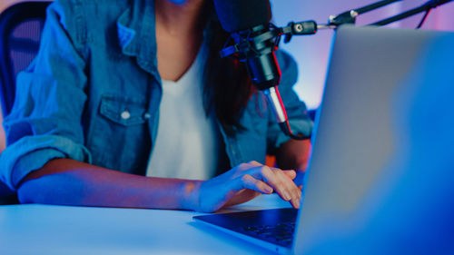 Midsection of woman using laptop on table