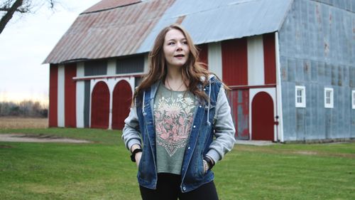 Portrait of beautiful young woman standing against building