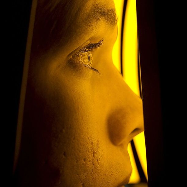 indoors, yellow, window, close-up, lifestyles, curtain, home interior, young adult, dark, young women, part of, person, sunlight, headshot, leisure activity, sensuality, light - natural phenomenon