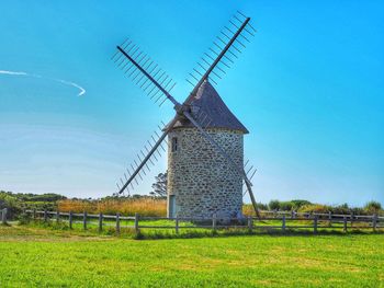 Traditional windmill on field against sky