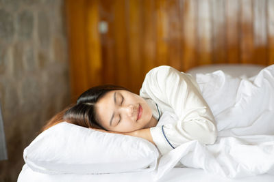 Mid adult woman sleeping on bed at home