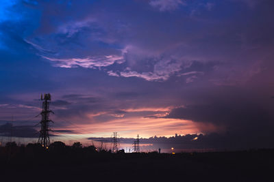 Silhouette electricity pylon against sky during sunset