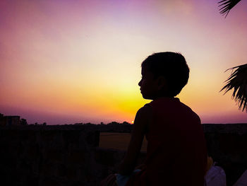 Silhouette woman looking at sunset