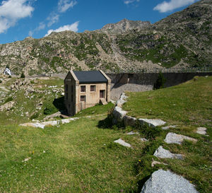 View of cottage by mountain against sky