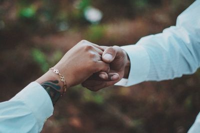 Midsection of couple holding hands