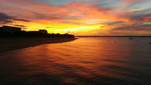 Scenic view of sea against cloudy sky at sunset