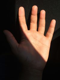 Close-up of human hand against black background