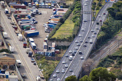 High angle view of traffic on city street and parked trucks with cargo container