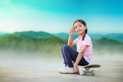 Portrait of smiling young woman sitting on mountain