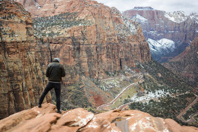 Rear view of man standing on rock