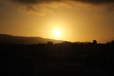 Silhouette buildings against sky during sunset