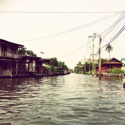 Houses by river against sky