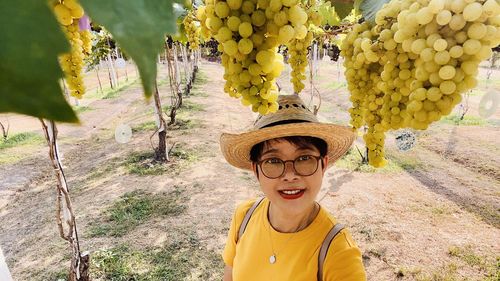 Portrait of smiling woman against yellow and plants