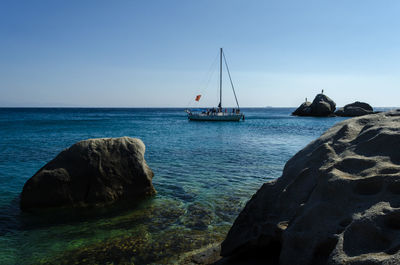 Sailboats on sea against clear sky