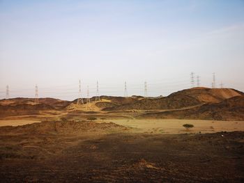 Electricity pylon on land against sky
