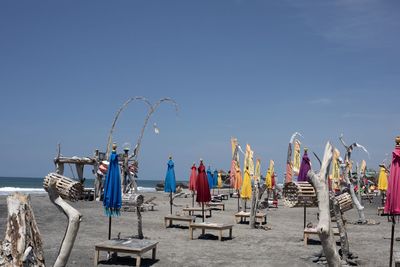 Panoramic view of lounge chairs on beach against clear sky