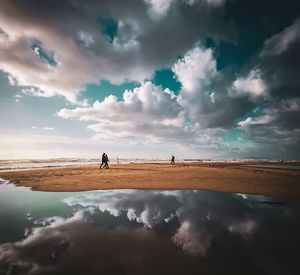 People on beach against sky