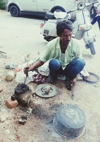 Full length of man sitting on barbecue grill