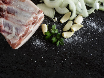 High angle view of rib meat with garlic and herbs on table