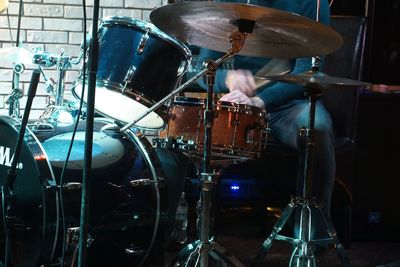 Midsection of drummer playing drums during event