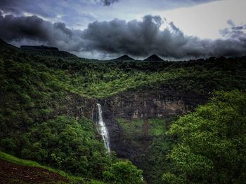 Scenic view of waterfall against sky