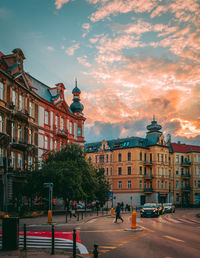 Exterior of buildings in town against sky at sunset