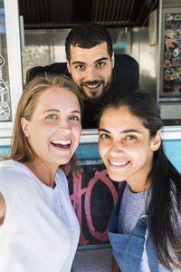 Portrait of confident young multi-ethnic colleagues at concession stand