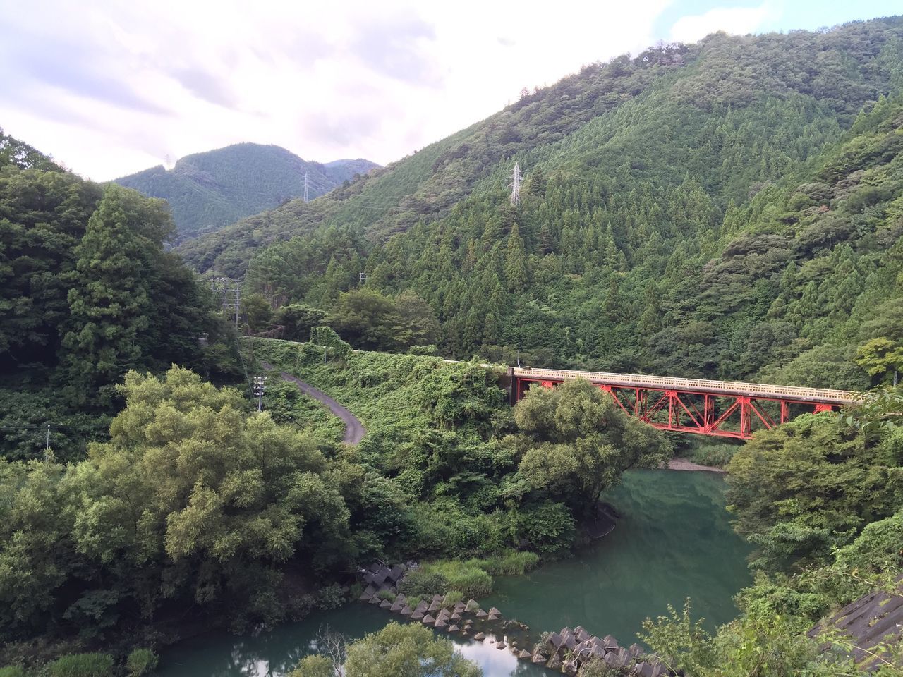 mountain, connection, bridge - man made structure, scenics, tree, sky, beauty in nature, tranquil scene, bridge, nature, tranquility, water, river, cloud - sky, day, mountain range, non-urban scene, outdoors, growth, lush foliage, green color, tourism, no people