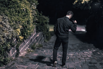 Rear view of man standing on footpath