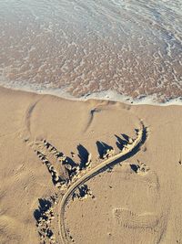 High angle view of footprints on sand at beach