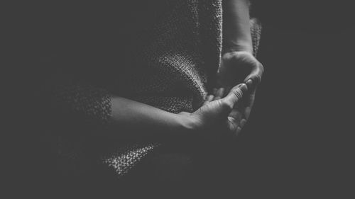 Close-up of woman hand on black background