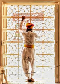 Rear view of man standing against door