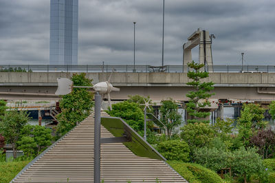 Bridge amidst plants and buildings against sky