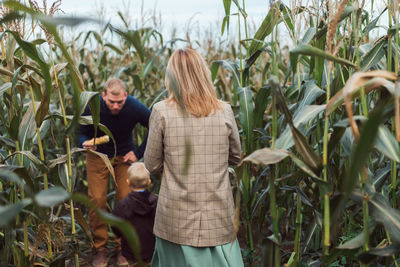 Family walking in corn field at autumn