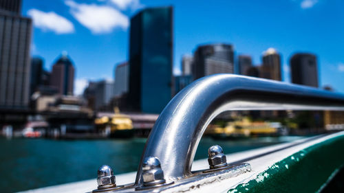 Close-up of boat in city against blue sky