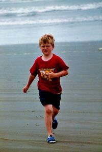 Full length of boy on beach against sky