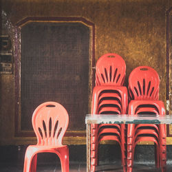 Close-up of empty chairs on table against wall