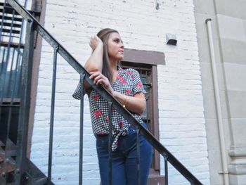 Low angle view of woman standing against building