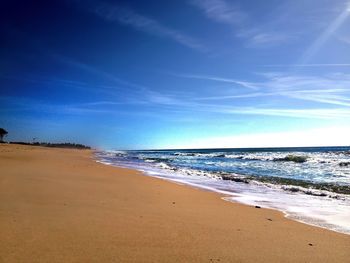 Scenic view of beach against blue sky