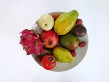 High angle view of fruits in plate against white background