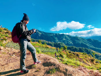 Man standing on mountain against sky