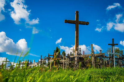 Low angle view of cross on field against sky