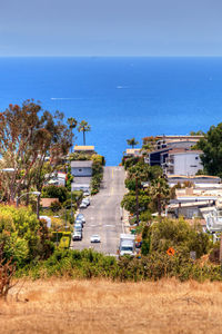 High angle view of city by sea against clear sky